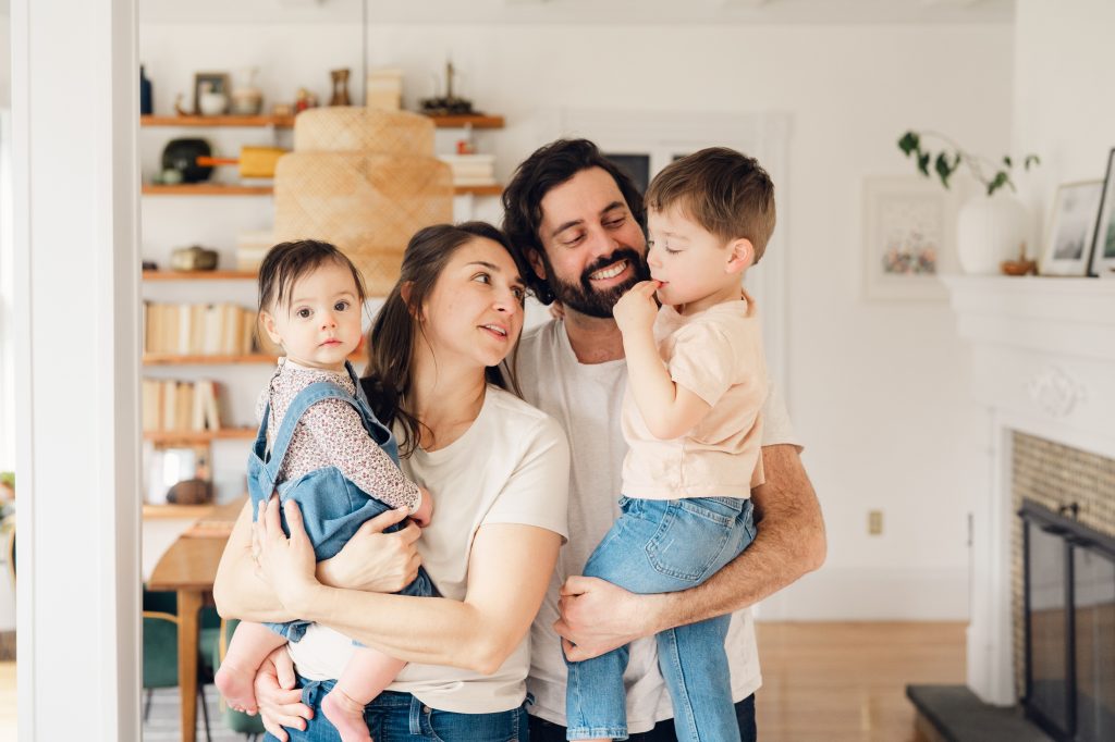 Portrait of a happy, smiling family holding their baby girl and little boy.